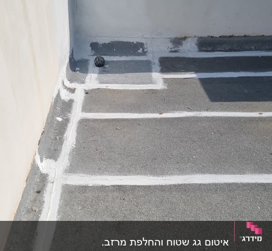 קווים לבנים של איטום על גג בטון אפור
